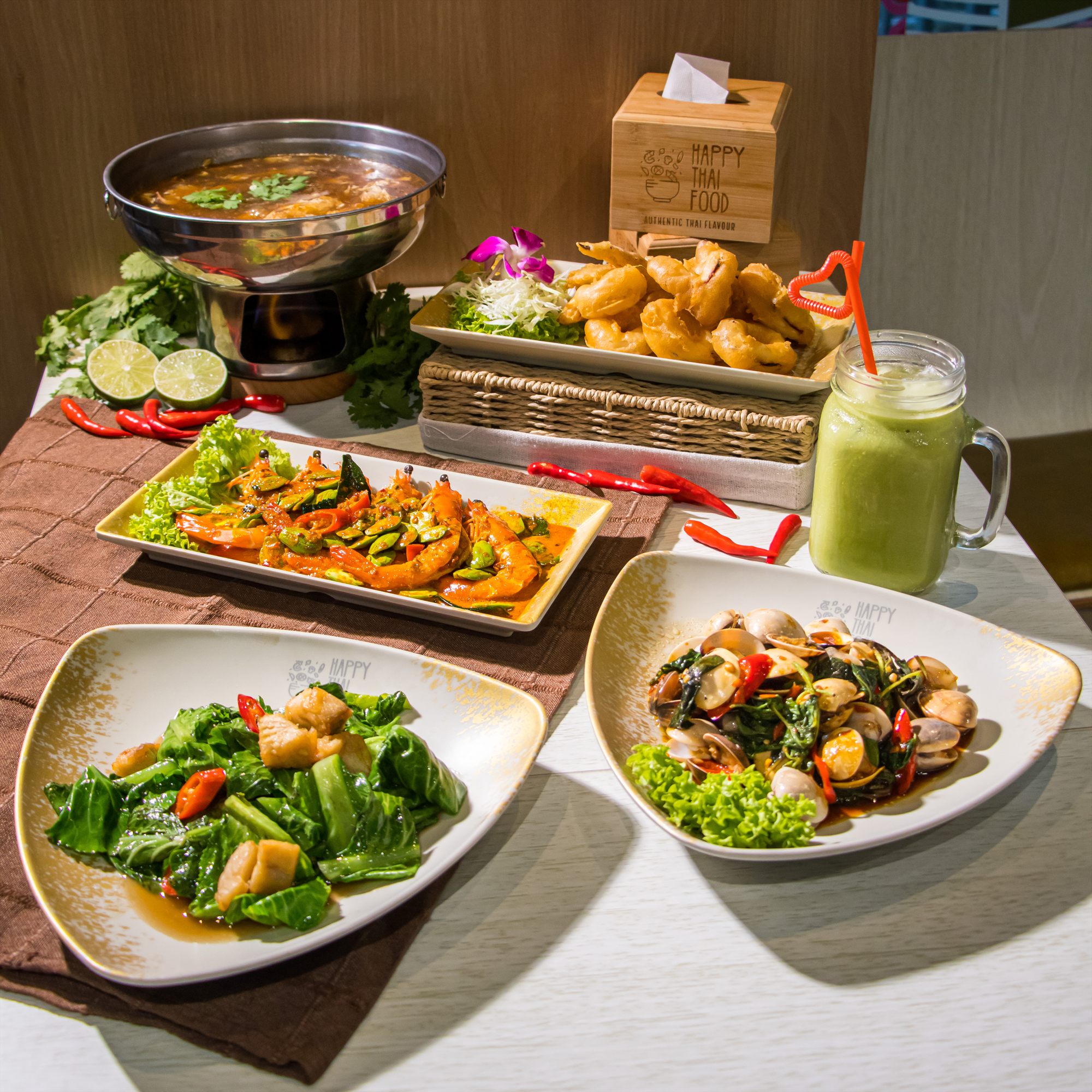A spread of Thai dishes served together at Happy Thai Food.